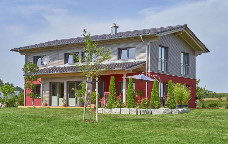 Modernes Holzhaus mit gemischter Fassade aus Massivholzbohlen und mineralischem Außenputz mit Farbakzenten