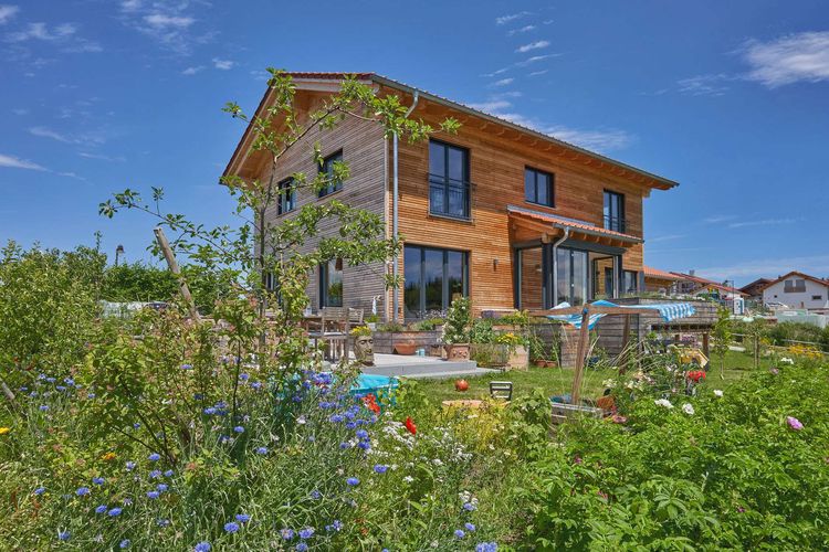 Modernes Holzhaus im Landhausstil mit durchgängiger Lärchenholzfassade und Holz-Alu-Fenstern
