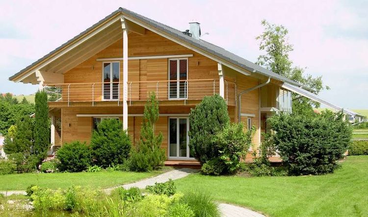 Holzhaus im Landhausstil, geschickt eingesetzte Mischfassade aus mineralischem Außenputz und Lärchenholz, Schiebläden elektrisch verstellbar