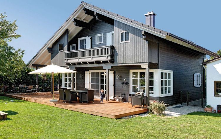 Traditionelles Holzhaus mit durchgängiger, grauer Holzfassade, inspiriert von unserem Musterhaus 'St. Johann'