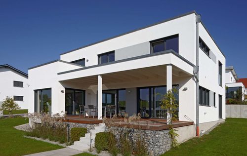 Modernes Holzhaus im Bauhausstil mit mineralischem Außenputz und Flachdach