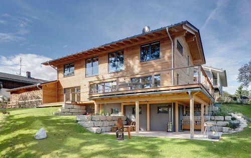 Modernes Holzhaus im Landhausstil mit durchgängiger Holzfassade