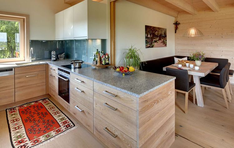 Die Küche des modernen Holzhauses im Landhausstil auf einem Hanggrundstück