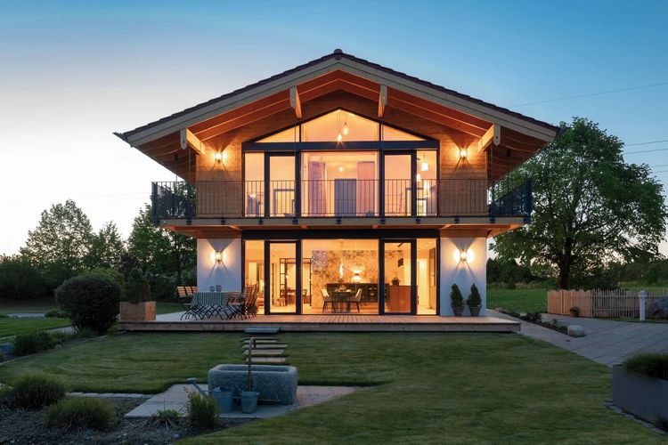 Klassisches Einfamilienhaus mit Satteldach, großer Glasfront und Abendbeleuchtung