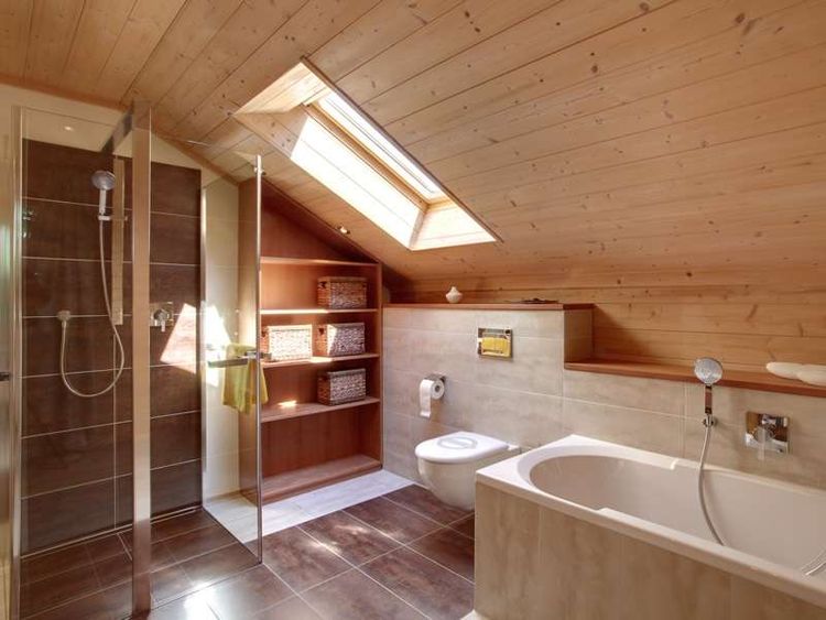 Das Badezimmer des traditionellen Musterhauses aus Holz mit Mischfassade aus Strukturputz und Lärchenholz