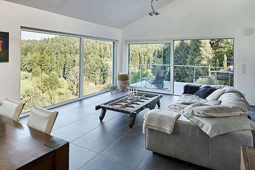 Offener Wohnbereich mit bodentiefen Panoramafenstern für einen wundervollen Ausblick