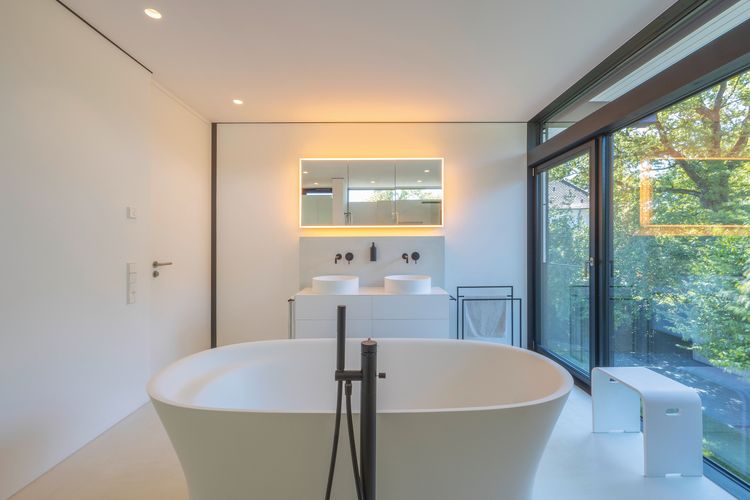 Modernes Badezimmer mit freistehender Badewanne und Blick ins Grüne