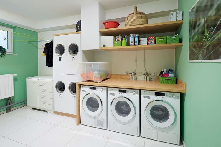 Hauswirtschaftsraum eines Mehrfamilienhauses mit mehreren Waschmaschinen und Trocknern