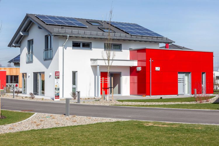 Mehrgenerationenhaus mit Photovoltaikanlage auf dem Dach und rotem Anbau