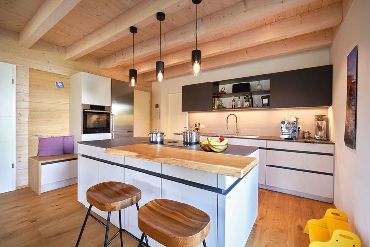 Die Küche des modernen Doppelhauses aus Holz mit Mischfassade aus mineralischem Außenputz und Holz