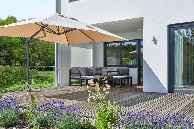 Überdachte Terrasse mit Sitzecke und Sonnenschirm