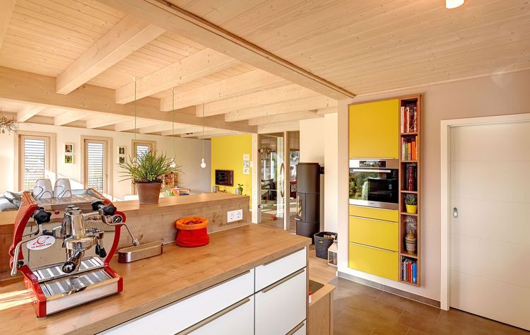 Die Küche des modernen Holzhauses mit mineralischem Außenputz und steilem Satteldach
