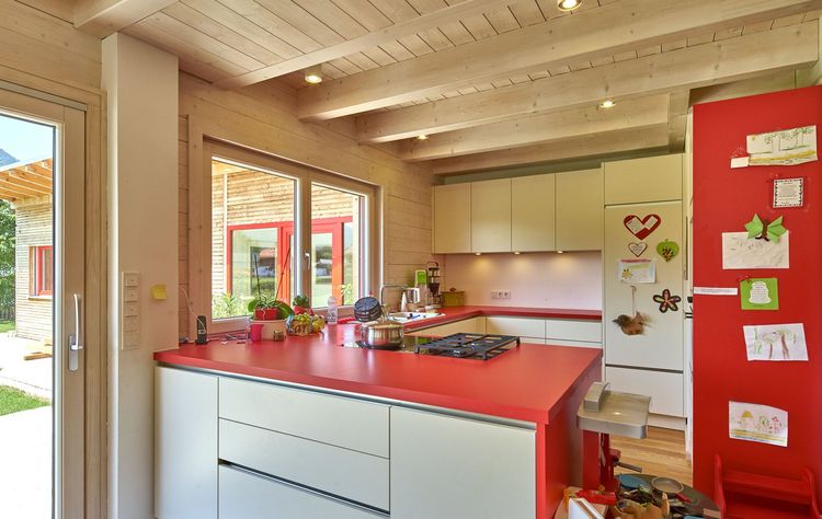 Die Küche des modernen Holzhauses mit durchgängiger Holzfassade, Nebengebäude mit Büro im Chiemgau