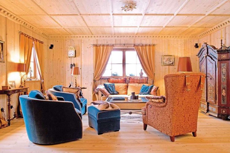 Gemütliches Wohnzimmer mit alpiner Einrichtung und klassischer Wand- und Deckenverkleidung aus Holz