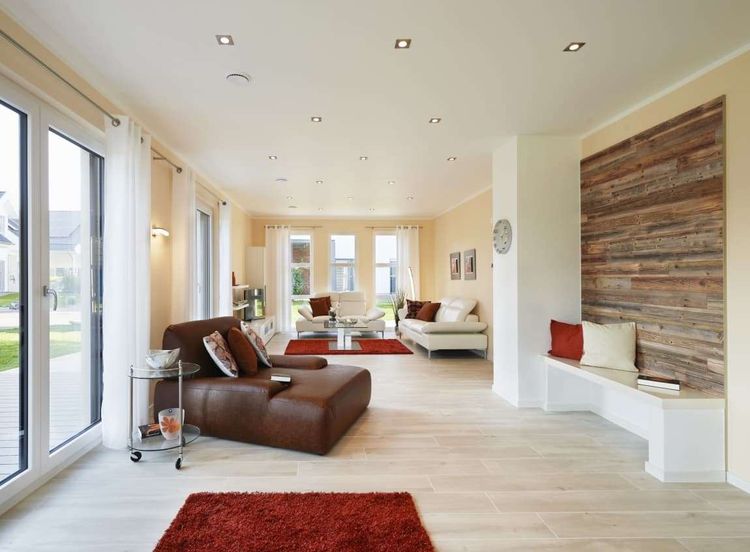 Offenes Wohnzimmer mit Wandverkleidung aus Holz als farblicher Akzent