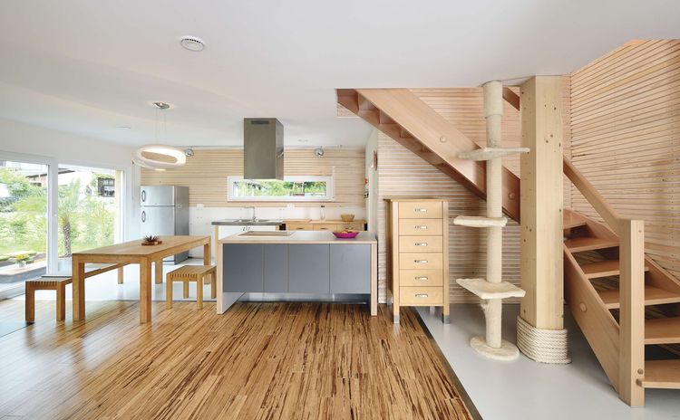 Offene Küche mit massivem Holztisch und Holztreppe mit Katzenbaum