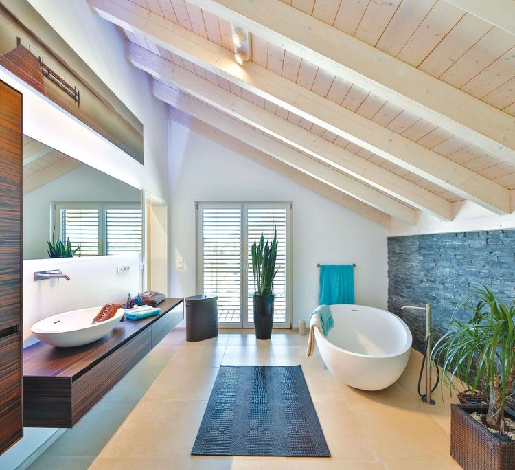 Badezimmer mit freistehender Badewanne und Dachschräge mit Holzverkleidung