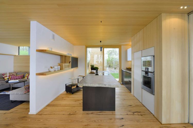 Küche mit Kücheninsel aus Stein und Wand- und Deckenverkleidung aus Holz