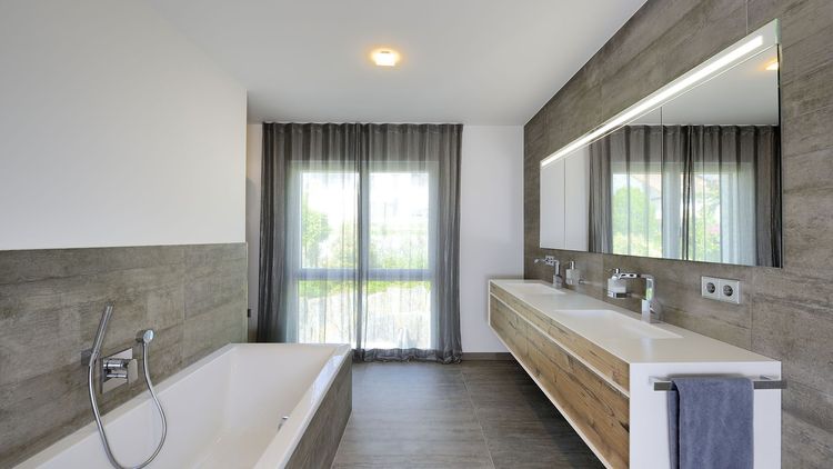 Badezimmer mit Badewanne und bodentiefen Fenstern