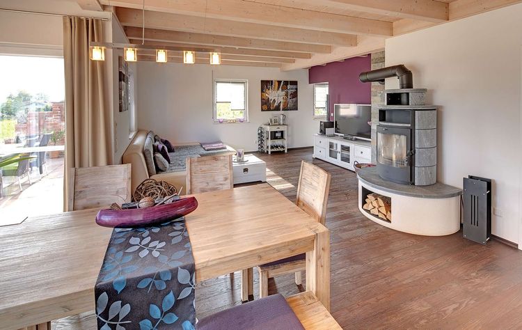 Der Wohn- und Essbereich des Holzhauses im Landhausstil mit gemischter Fassade aus mineralischem Putz und Holz