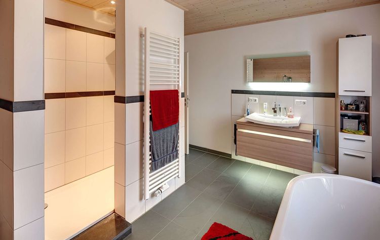 Das Badezimmer des Holzhauses im Landhausstil mit gemischter Fassade aus mineralischem Putz und Holz