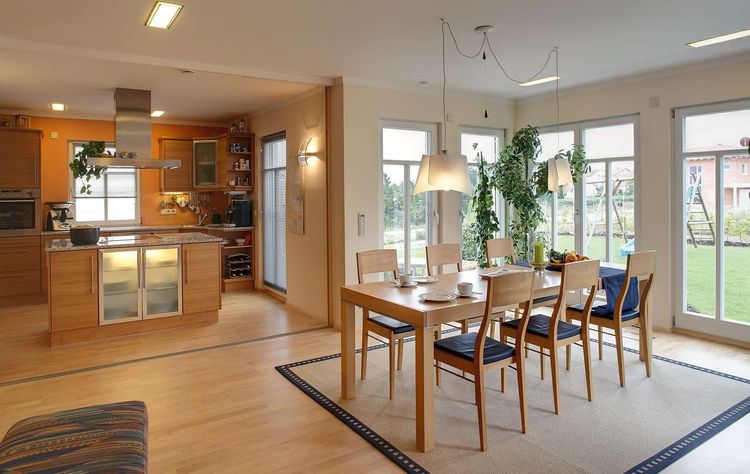 Die Küche und der Essbereich des modernen Holzhauses mit mineralischem Außenputz