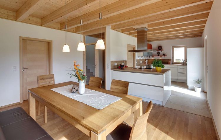 Die Küche des modernen Holzhauses mit Pultdach, Putzfassade und Schiebeläden aus Lärche
