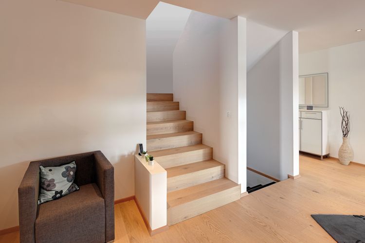 Die minimalistischen Treppen des modernen Holzhauses im Bauhausstil mit mineralischem Außenputz und Flachdach