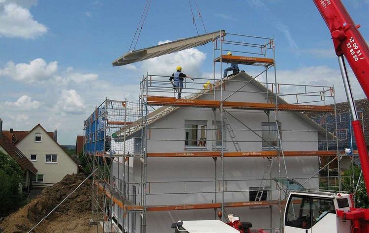 Baustelle eines Einfamilienhaus mit Gerüst bei der Sanierung