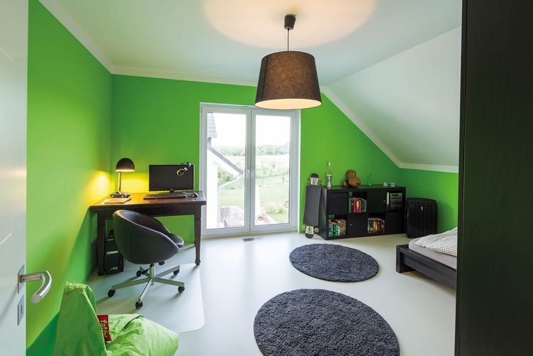 Kinderzimmer mit Schreibtisch und grün gestrichenen Wänden