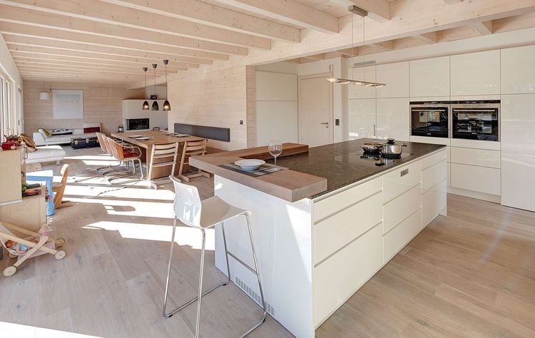 Die Küche des modernen Holzhauses im Landhausstil mit durchgängiger Holzfassade