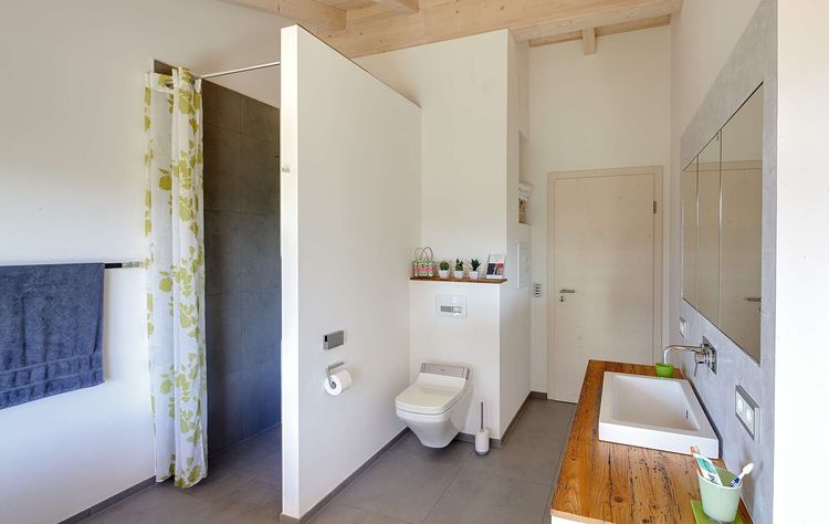 Das Badezimmer des modernen Holzhauses im Landhausstil mit durchgängiger Holzfassade