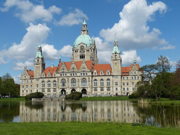 Außenansicht des Hannover Rathaus mit einem Teich im Vordergrund