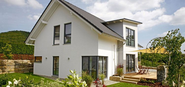 Modernes Einfamilienhaus von Partner Haus mit Satteldach, Zwerchhaus und Holzterrasse