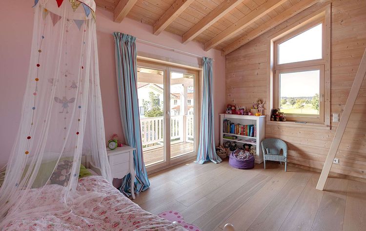 Das Kinderzimmer des modernen Holzhauses mit umlaufendem Balkon und Mischfassade aus Holz und Putz