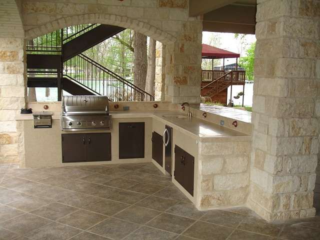 Hochwertige Outdoor-Küche aus Stein in L-Form mit eingebautem Grill