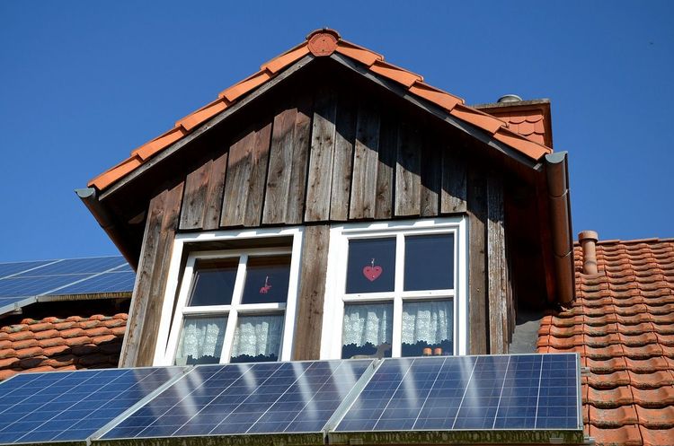 Dachgaube mit Satteldach, Holzverschalung und Solarpanels