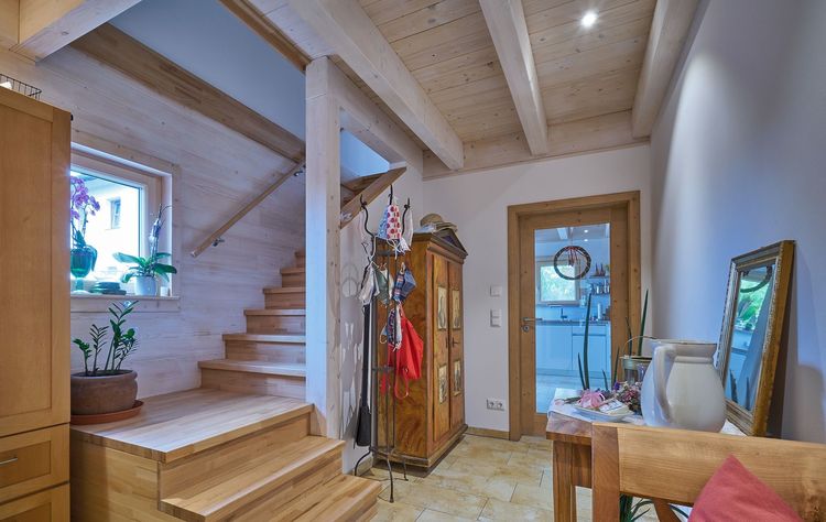 Die Diele des modernen Holzhauses im Landhausstil mit durchgängiger Lärchenholzfassade und großer Terrasse