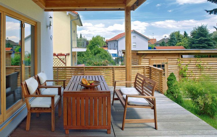 Gemütliche Terrasse mit Garten und Holzlamellenzaun als Sichtschutz