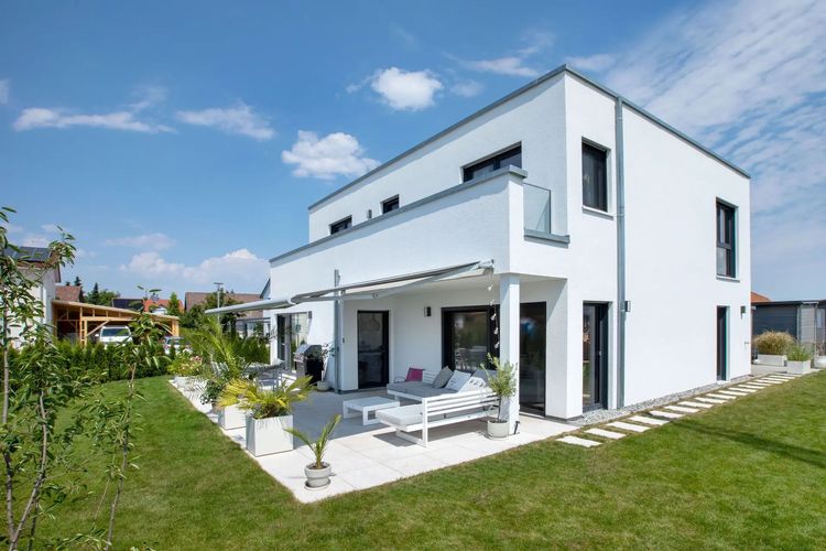 Modernes Effizienzhaus von TALBAU-Haus im Bauhaus-Stil mit Flachdach und überdachter Terrasse