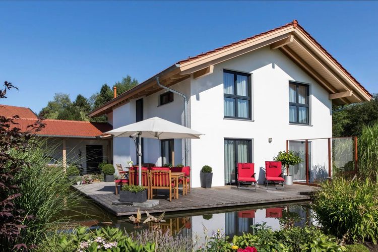 Modernes Einfamilienhaus von Regnauer mit Satteldach, Terrasse und Teich im Garten
