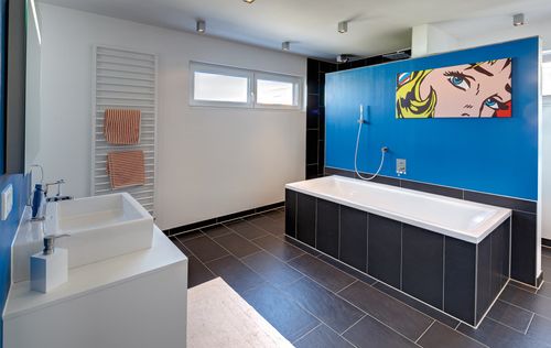 Das Badezimmer des modernen Holzhauses mit mineralischem Außenputz und Flachdach