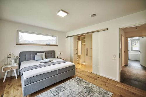 NORDHAUS - Modernes und weitläufiges Schlafzimmer mit begehbarem Kleiderschrank | Hausbau made im Bergischen