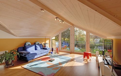 Ein Dachgeschoss des modernes Zweifamilienhauses aus Holz mit Wintergarten