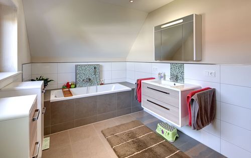 Das Badezimmer des modernen Holzhauses mit mineralischem Außenputz und steilem Satteldach