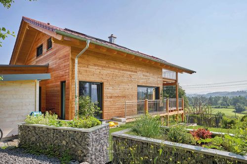 Modernes Holzhaus im Landhausstil mit Holzfassade, Holz-Alu-Fenstern und großzügigen Balkonen