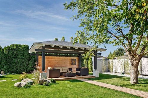 Dieser Pavillon aus Holz überdacht die Terrasse darunter gemütlich und wetterfest. So entsteht ein Rückzugsort im Garten, der fast ganzjährig genutzt werden kann.