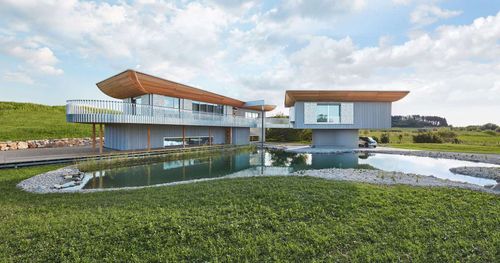 Modernes Designhaus von Baufritz mit großem Garten und Teich