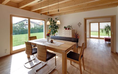 Der Essbereich des modernen Holzhauses mit Pultdach, Putzfassade und Schiebeläden aus Lärche