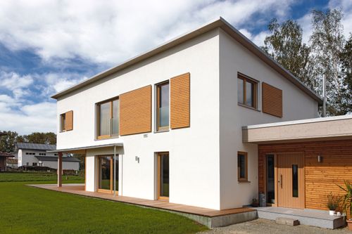 Modernes Holzhaus mit Pultdach, Putzfassade und Schiebeläden aus Lärche